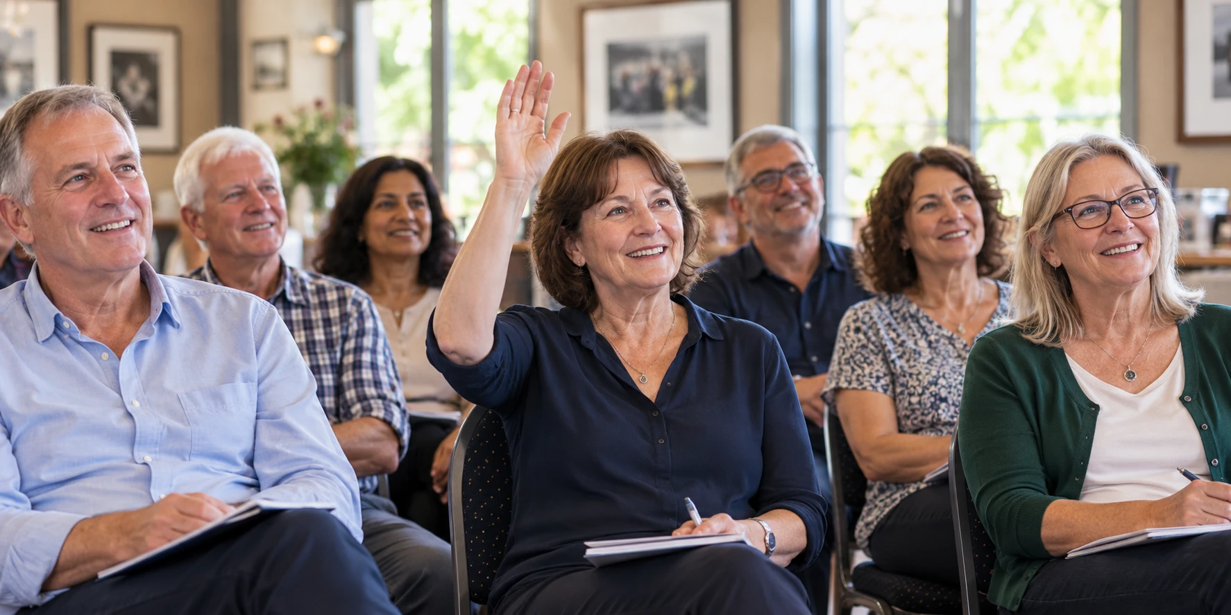 Club members enjoying a talk, with one audience member raising a hand to ask a question